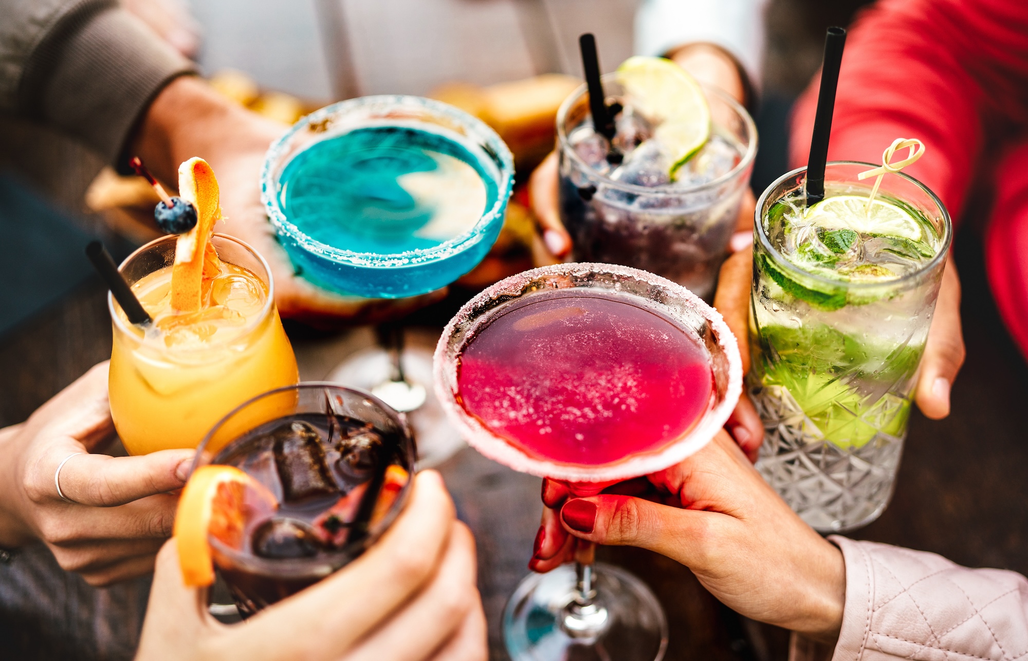 A diverse group of friends toasting with colorful cocktails and martinis at Blue Martini Brickell, a top choice for those searching for the best bars near me in Miami.