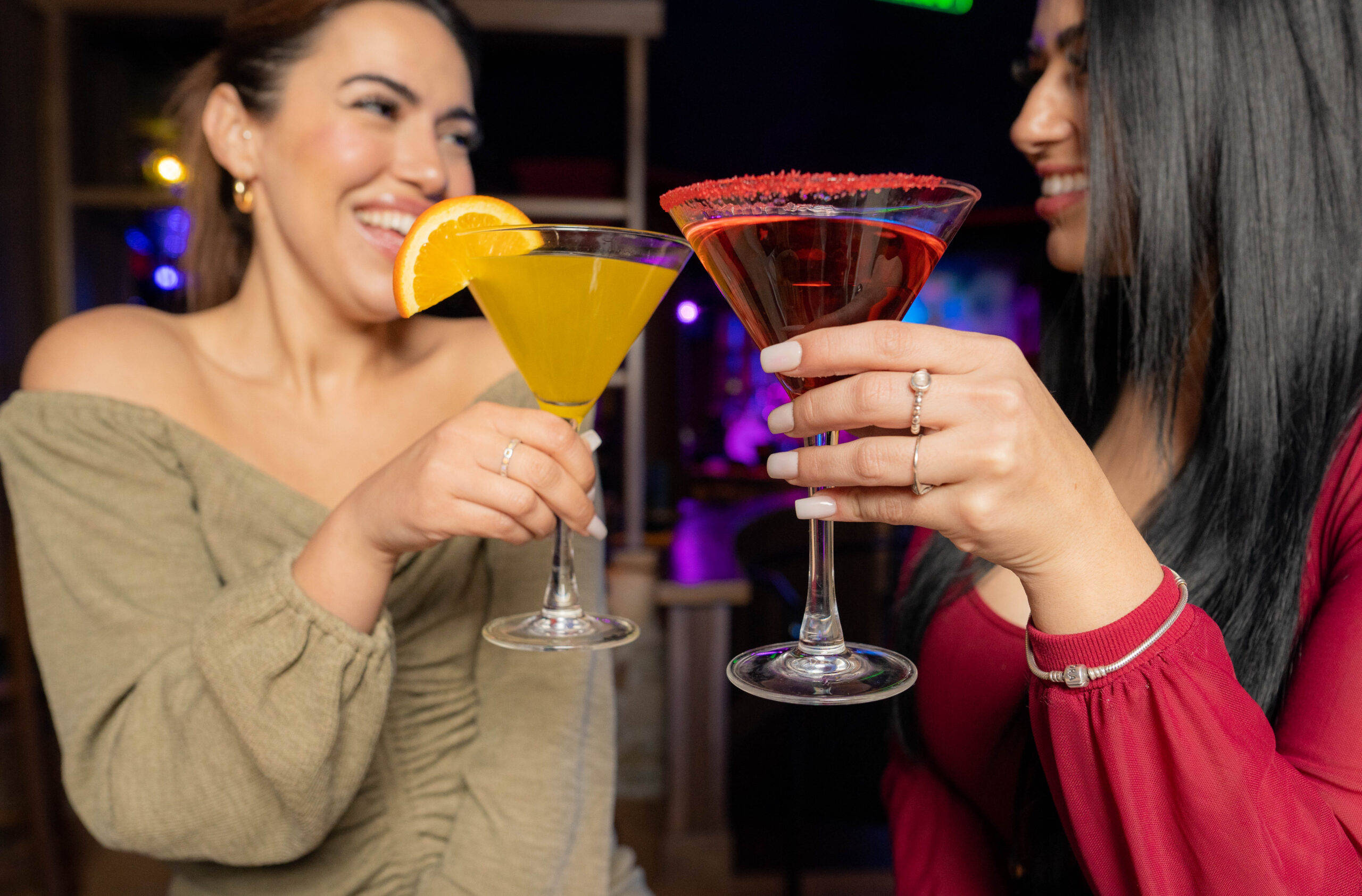 Two women toasting with signature martinis during a girls night at Blue Martini 